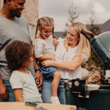 Family of four by a grill outdoors
